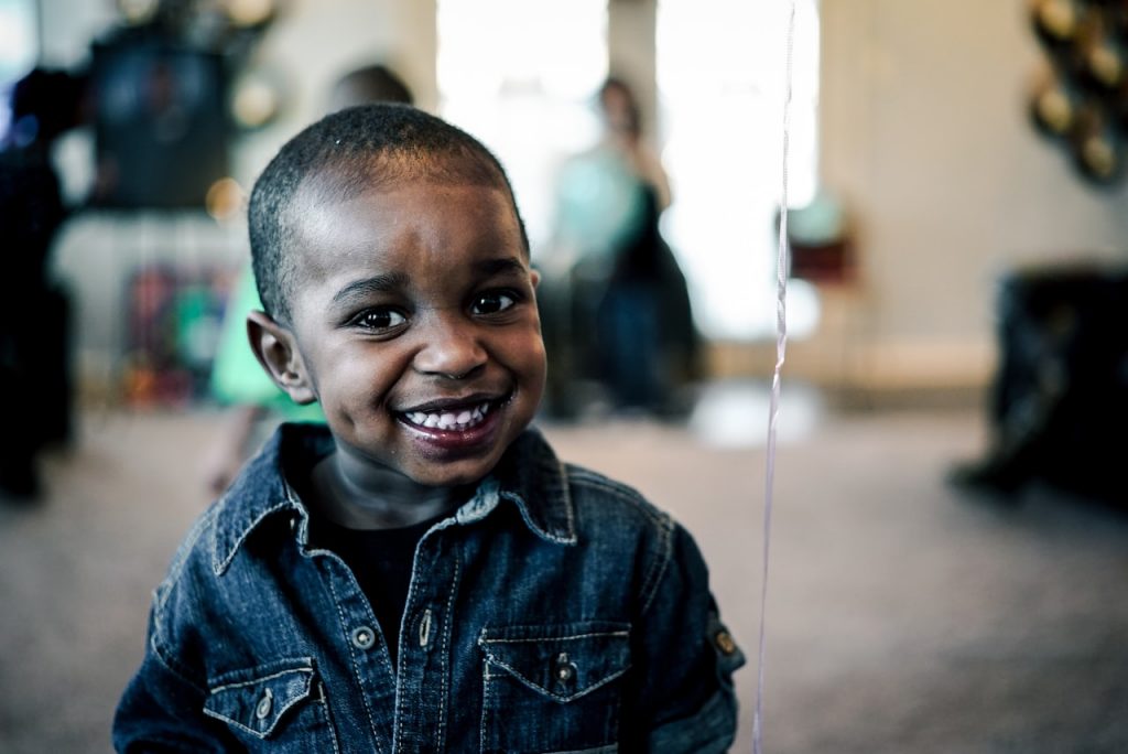small smiling black boy in a denim jacket