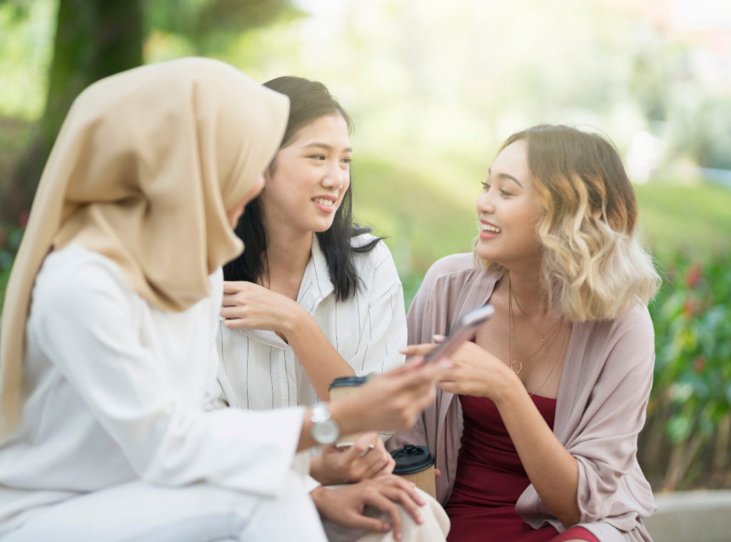 Three young women talking, smiling and sharing stories