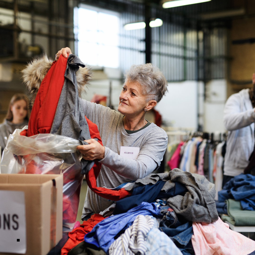 Elderly woman sifting through a donation box