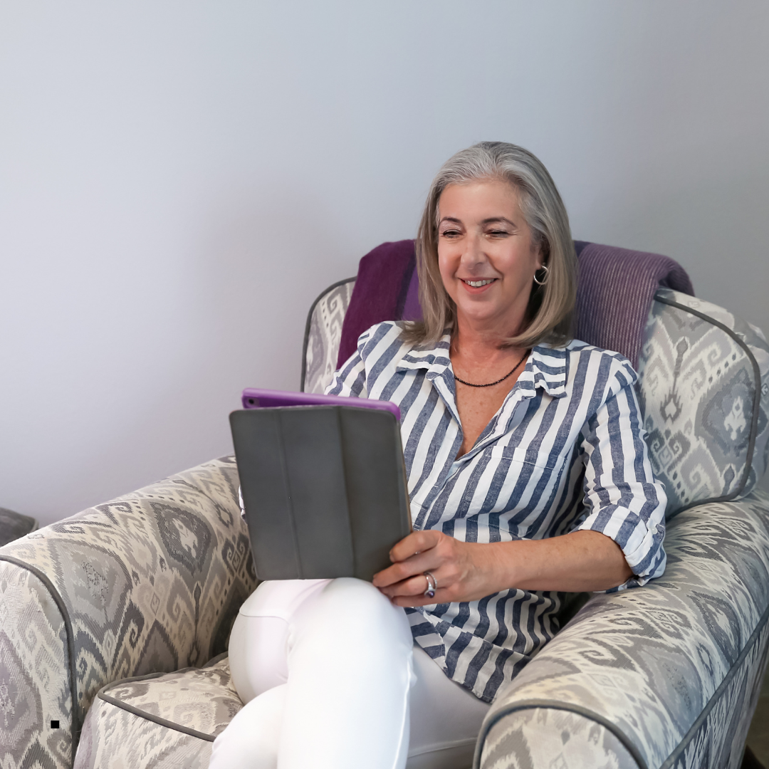 An elderly white woman holding her laptop