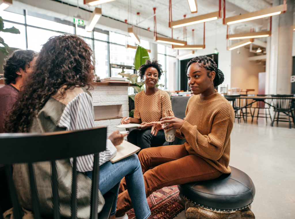 Three women, two black women, one white engaged in conversation