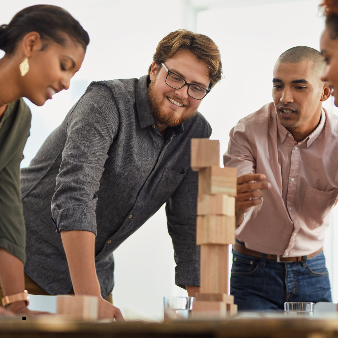 Black woman and two white male looking at building blocks