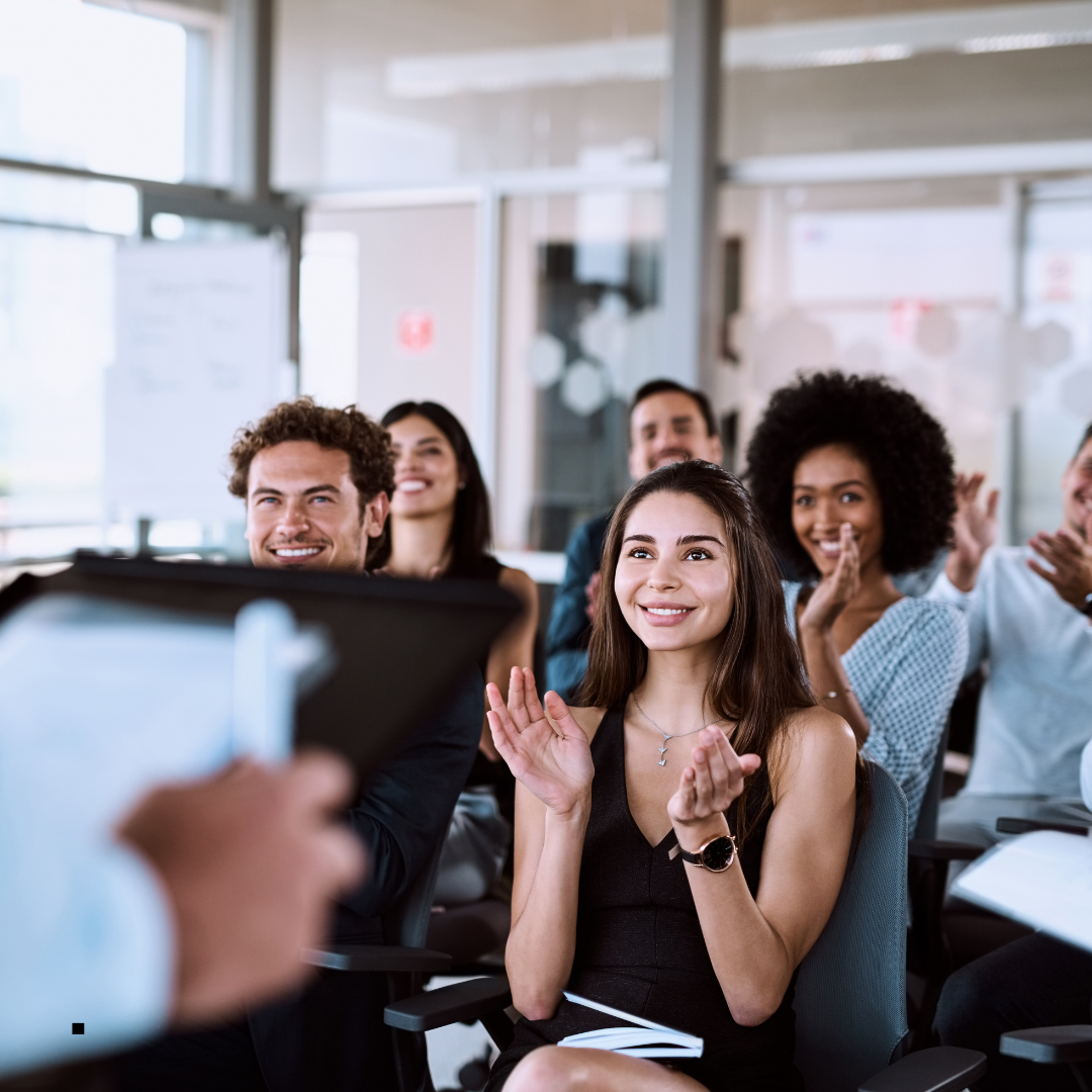 A mixed group of people applauding and smiling