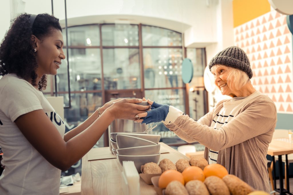 Cheerful poor woman being thankful for the soup