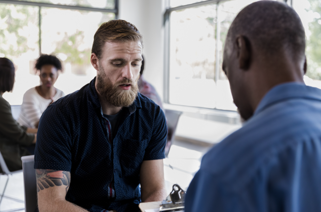 White man getting support from a black man