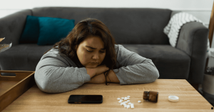 Woman with pills on the table with mobile phone