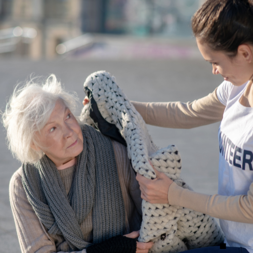 Elderly white woman being supported by a yound nurse